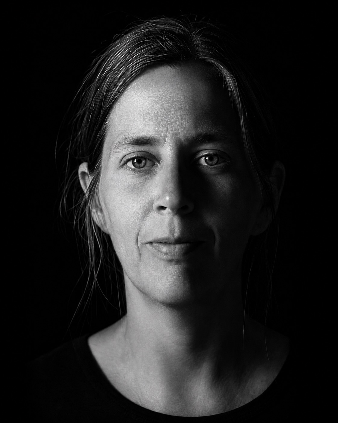 Julia Ljungström-Caunt i svartvitt porträtt, med ena sidan av ansiktet upplyst mot en mörk bakgrund.